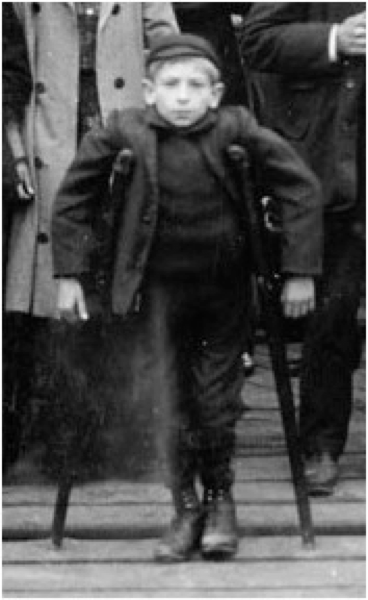 Anna Maria Carlevaris discusses this photo at some length in her dissertation, and provides an interpretation of the symbolism of the image: “The crippled [sic] boy is centered in the composition and stands apart from the group behind him; he probably has been positioned there by the photographer. Neither the group, nor the boy, are close enough to the camera to evoke feelings of intimacy from the viewer but neither are they far enough away not to be recognized [. . .] by lessening the personalizing or honorific aspect of the photograph a distance between the viewer and the subject is constructed [. . .] the boy with crutches, so 'obviously' defective, dispassionately gazes back across an infinite gulf of silence. The boy wears the sign of his difference; his body displays the reason for his deportation. The other figures, because they are members of this group, are also defective in some way [their proximity to the boy is incriminating]. Their failure does not announce itself physically, but it is implied by association. (38)”
