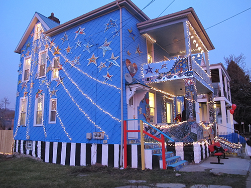 Image of the corner of the house from Figure 6. Both the side and the front of the house are now decorated with string lights.
