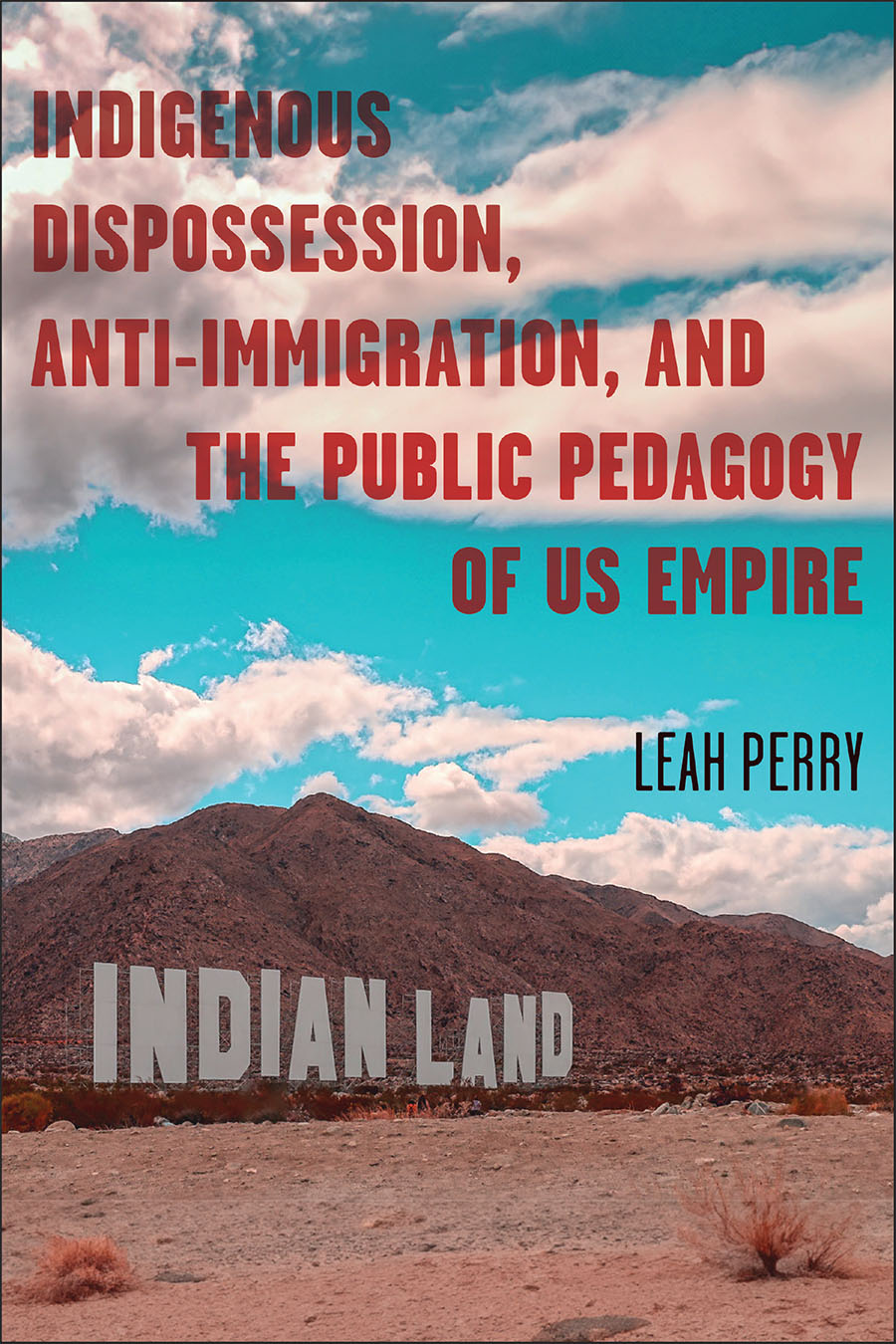 Front cover of Indigenous Dispossession, Anti-Immigration, and the Public Pedagogy of US Empire by Leah Perry, featuring a photo of a hilly desert landscape with a large sign that reads 'Indian Land'.