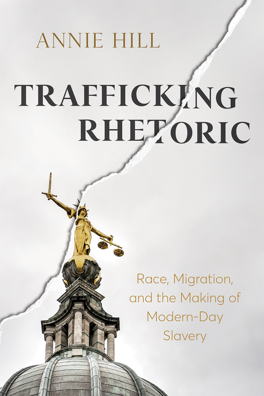 Front cover of Trafficking Rhetoric: Race, Migration, and the Making of Modern-Day Slavery by Annie Hill, featuring a close-up of Lady Justice atop the Old Bailey courthouse in London, set against a gray sky. A crack runs across the image and through Lady Justice.